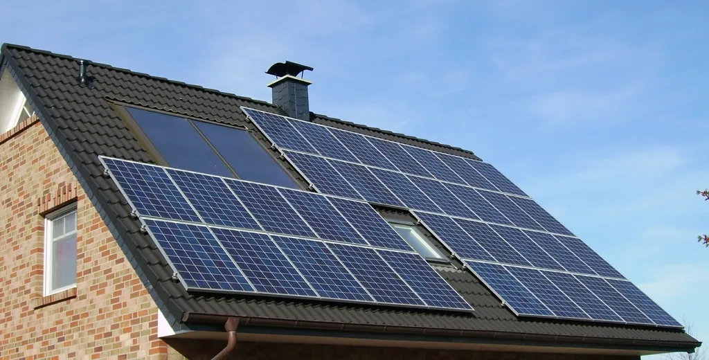 Solar panels on a roof photographed close against the sky.