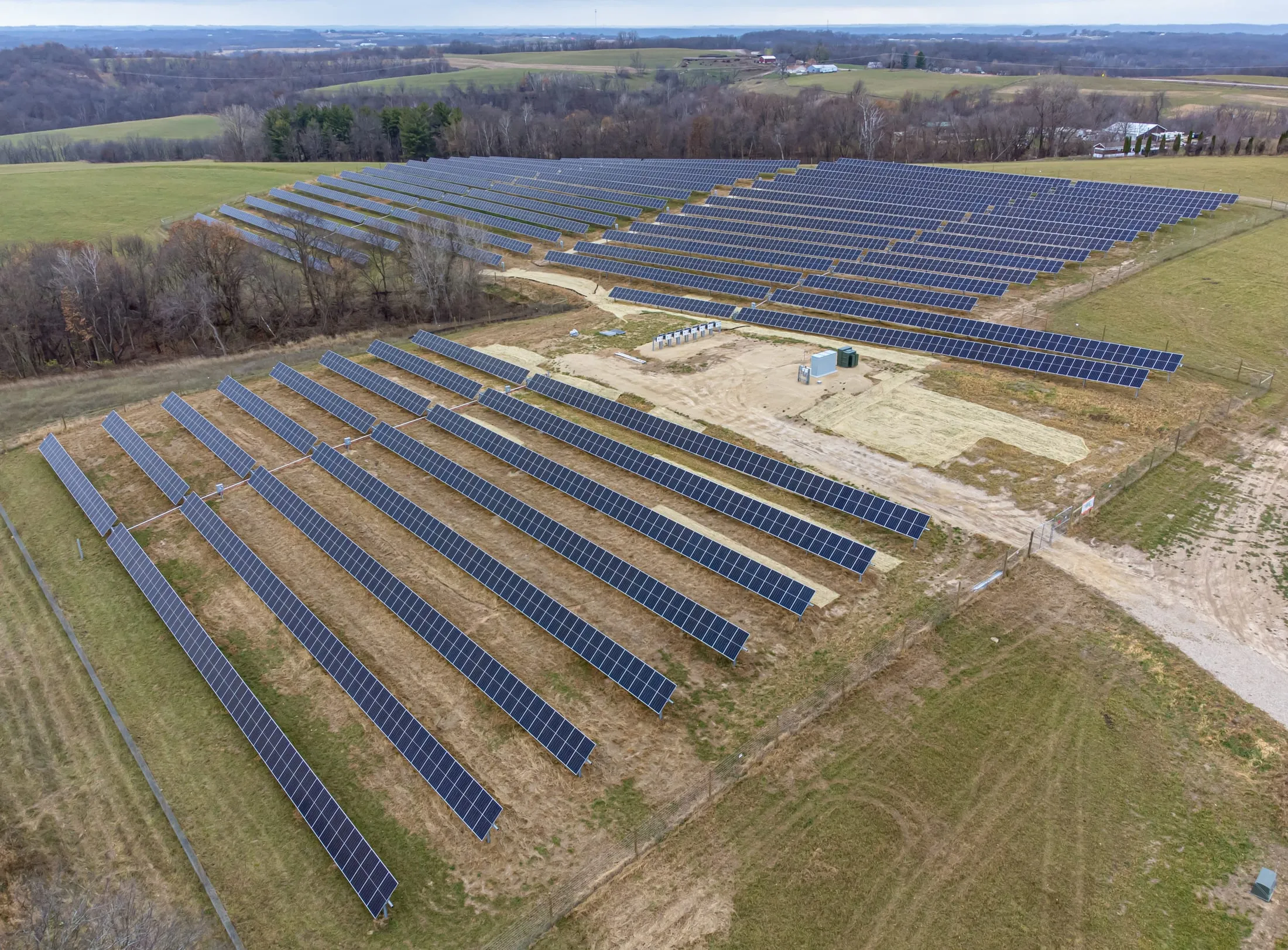 An aerial view of a large solar array laid out in rows.